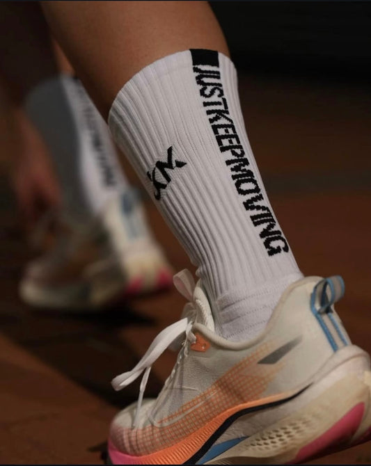 JKM White sock with 'JUST KEEP MOVING' text on a shoe